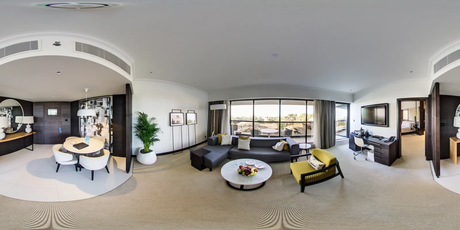 The 360° photo of a hotel suite's lounge laid out flat: the dining table, the sofa by the windows and the desk run across the whole width, with the ceiling stretched along the top and the floor along the bottom
